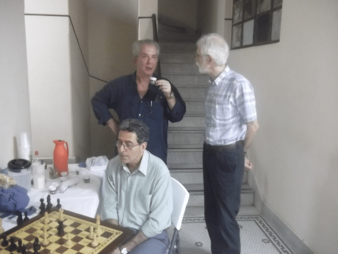 Sérgio Sundaus, assíduo visitante dos torneios da ALEX, conversa com o Mestre Nacional David Borensztajn, que toma seu cafezinho enquanto Antonio Elias pensa na posição de sua partida.